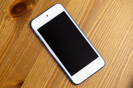 image de la page d'accueil, rubrique entre nous représentant un portable téléphone blanc sur un fond bois clair